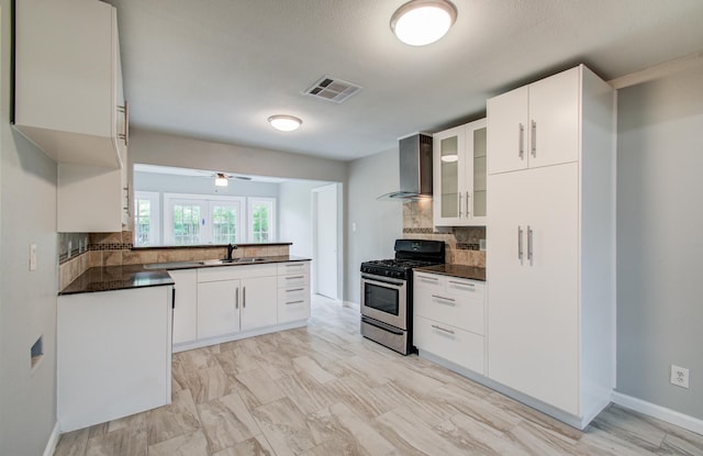 4621 W 43rd St, Houston, TX 77092 - kitchen with stainless steel range with gas stovetop, dark countertops, wall chimney exhaust hood, a sink, and backsplash