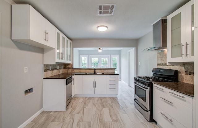 4621 W 43rd St, Houston, TX 77092 - kitchen featuring appliances with stainless steel finishes, wall chimney range hood, decorative backsplash, ceiling fan, and a sink