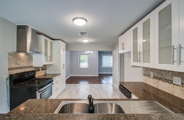 4621 W 43rd St, Houston, TX 77092 - kitchen with wall chimney range hood, stainless steel appliances, dark stone counters, decorative backsplash, and white cabinets