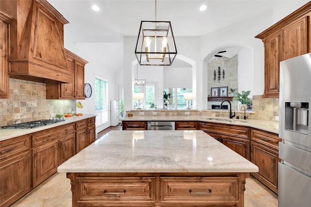 5451 Harvest Oak Landing Dr, Spring, TX 77386 - kitchen with appliances with stainless steel finishes, a sink, a chandelier, custom exhaust hood, and brown cabinets