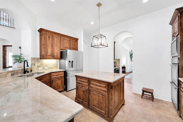 5451 Harvest Oak Landing Dr, Spring, TX 77386 - kitchen with stainless steel appliances, a sink, arched walkways, decorative backsplash, and recessed lighting