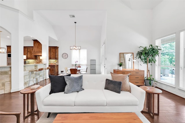 5451 Harvest Oak Landing Dr, Spring, TX 77386 - living area featuring high vaulted ceiling, a chandelier, wood finished floors, and arched walkways