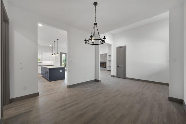 1806 Athens Dr, Roman Forest, TX 77357 - unfurnished dining area with a chandelier, wood finished floors, and baseboards