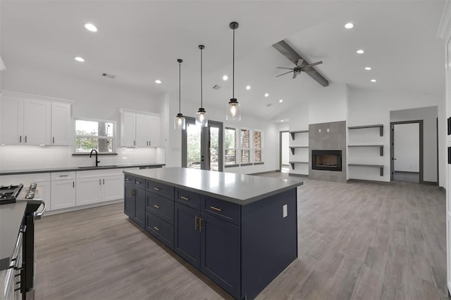 1806 Athens Dr, Roman Forest, TX 77357 - kitchen featuring stainless steel gas range, a sink, beamed ceiling, white cabinets, and a ceiling fan