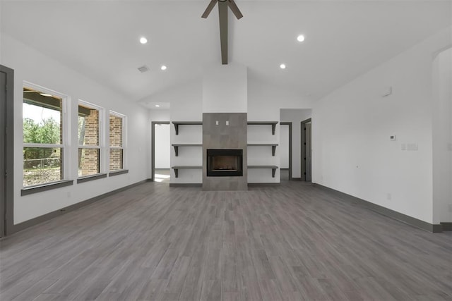 1806 Athens Dr, Roman Forest, TX 77357 - unfurnished living room featuring beam ceiling, high vaulted ceiling, ceiling fan, a tiled fireplace, and baseboards