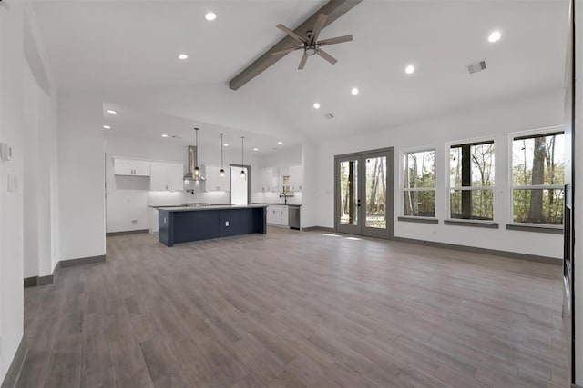 1806 Athens Dr, Roman Forest, TX 77357 - unfurnished living room featuring beamed ceiling, a ceiling fan, wood finished floors, baseboards, and recessed lighting