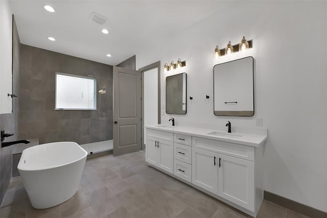 1806 Athens Dr, Roman Forest, TX 77357 - full bathroom featuring double vanity, walk in shower, a soaking tub, and recessed lighting