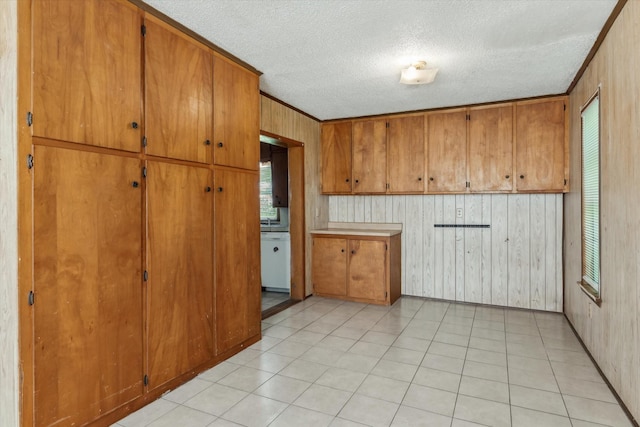 1498 Fm 279, Ben Wheeler, TX 75754 - kitchen with brown cabinetry, a textured ceiling, wooden walls, and light countertops
