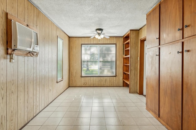 1498 Fm 279, Ben Wheeler, TX 75754 - unfurnished dining area featuring ceiling fan, wood walls, a wall unit AC, built in features, and a textured ceiling