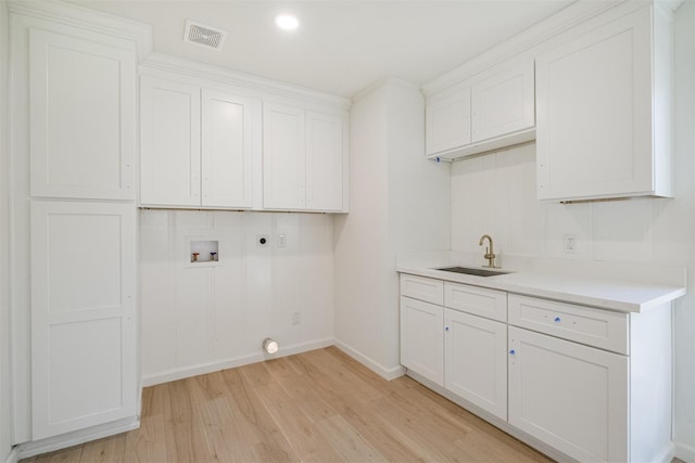 9419 Campbell Rd, Houston, TX 77080 - laundry room featuring hookup for an electric dryer, hookup for a washing machine, light wood-style floors, cabinet space, and baseboards
