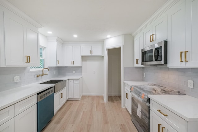 9419 Campbell Rd, Houston, TX 77080 - kitchen with stainless steel appliances, light wood-type flooring, white cabinets, decorative backsplash, and baseboards