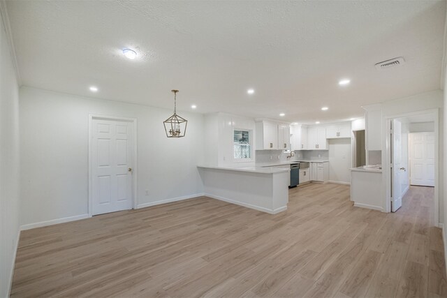 9419 Campbell Rd, Houston, TX 77080 - kitchen with light wood finished floors, a peninsula, white cabinetry, dishwashing machine, and light countertops