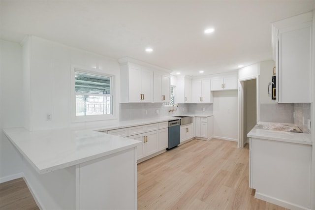 9419 Campbell Rd, Houston, TX 77080 - kitchen with a peninsula, appliances with stainless steel finishes, light wood-type flooring, decorative backsplash, and a sink