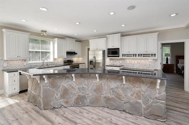 27140 Fm 365, Beaumont, TX 77705 - kitchen featuring stainless steel appliances, a sink, ornamental molding, a kitchen breakfast bar, and dark stone countertops