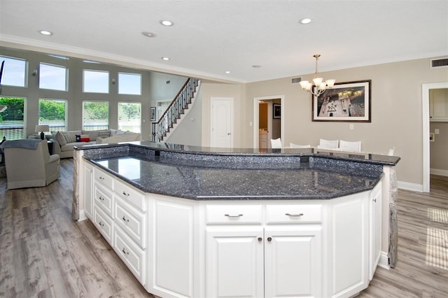 27140 Fm 365, Beaumont, TX 77705 - kitchen with ornamental molding, a chandelier, light wood-style floors, baseboards, and dark stone countertops