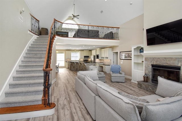 27140 Fm 365, Beaumont, TX 77705 - living room featuring a high ceiling, ceiling fan, stairway, light wood-style flooring, and baseboards