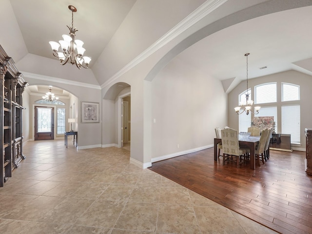 5411 Cedar Elm Ln, Fulshear, TX 77441 - dining space featuring a chandelier, arched walkways, vaulted ceiling, tile patterned flooring, and baseboards