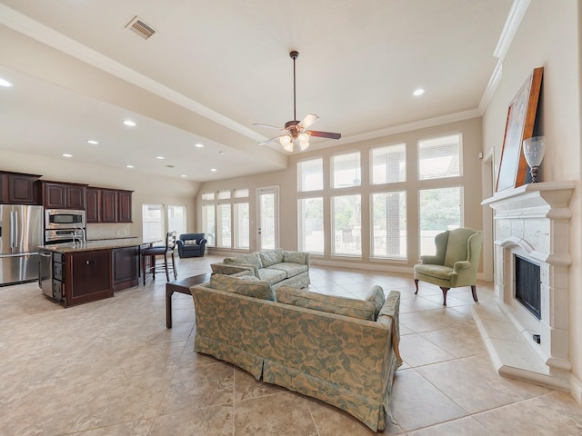 5411 Cedar Elm Ln, Fulshear, TX 77441 - living room with ornamental molding, ceiling fan, recessed lighting, a fireplace with raised hearth, and light tile patterned floors