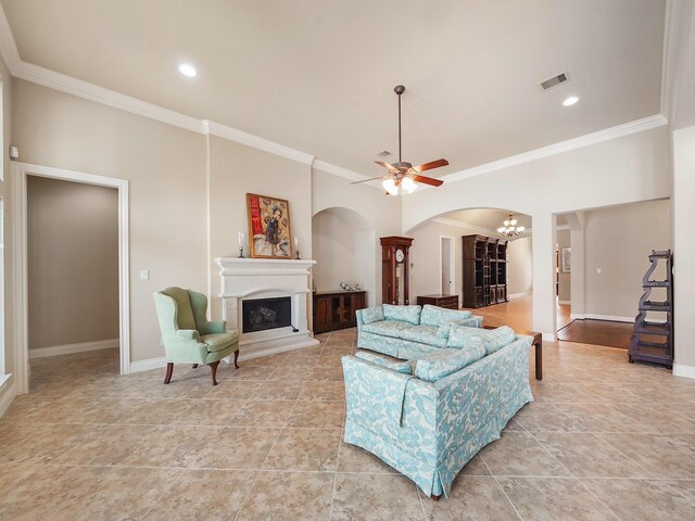 5411 Cedar Elm Ln, Fulshear, TX 77441 - living area featuring arched walkways, a fireplace with raised hearth, crown molding, a chandelier, and baseboards