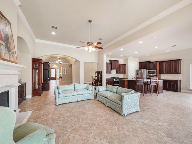 5411 Cedar Elm Ln, Fulshear, TX 77441 - living room featuring arched walkways, crown molding, ceiling fan, a fireplace with raised hearth, and light tile patterned floors
