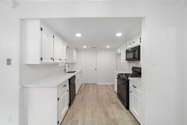 12310 New Brunswick Dr, Houston, TX 77089 - kitchen with black appliances, a sink, white cabinetry, decorative backsplash, and light wood finished floors