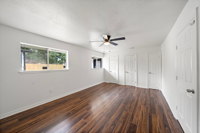 12310 New Brunswick Dr, Houston, TX 77089 - unfurnished bedroom with dark wood-style floors, baseboards, two closets, and a ceiling fan