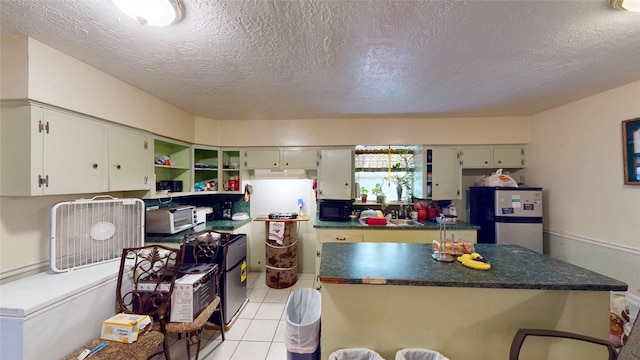 6130 Hartwick Rd, Houston, TX 77016 - kitchen featuring freestanding refrigerator, open shelves, dark countertops, a textured ceiling, and a kitchen island