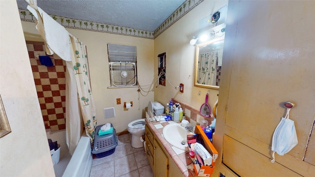 6130 Hartwick Rd, Houston, TX 77016 - full bathroom featuring toilet, vanity, a textured ceiling, tile patterned flooring, and shower / tub combo