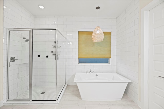 409 Stratus View Ct, Katy, TX 77493 - full bathroom featuring a stall shower, a freestanding tub, tile walls, and tile patterned floors