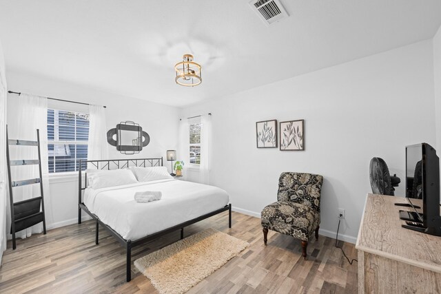 729 Kyle St, Angleton, TX 77515 - bedroom with wood finished floors, a chandelier, and baseboards