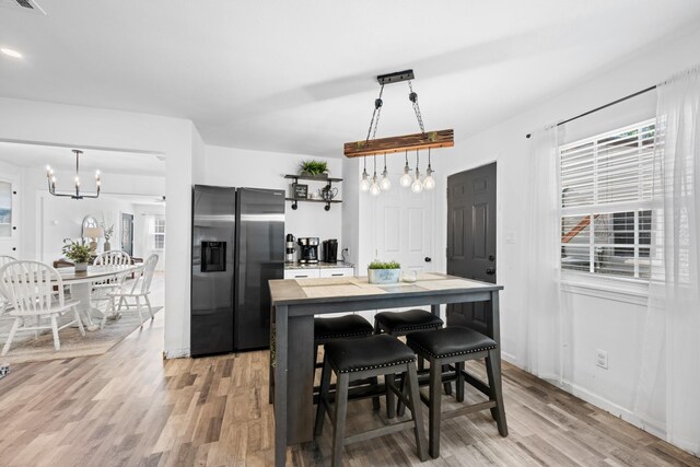 729 Kyle St, Angleton, TX 77515 - kitchen featuring stainless steel refrigerator with ice dispenser, a chandelier, light wood-type flooring, and decorative light fixtures