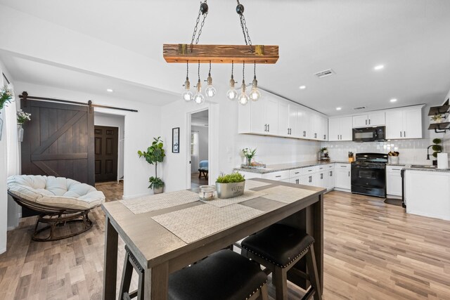 729 Kyle St, Angleton, TX 77515 - dining space featuring recessed lighting, light wood-type flooring, and a barn door