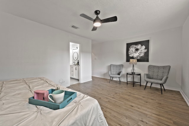 3247 Bolton Gardens Dr, Houston, TX 77066 - bedroom with wood finished floors, baseboards, a ceiling fan, ensuite bathroom, and a textured ceiling