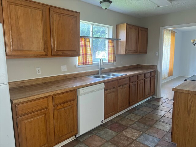 2134 Collingsfield Dr, Sugar Land, TX 77478 - kitchen featuring white appliances, a sink, brown cabinetry, dark stone finish flooring, and butcher block countertops