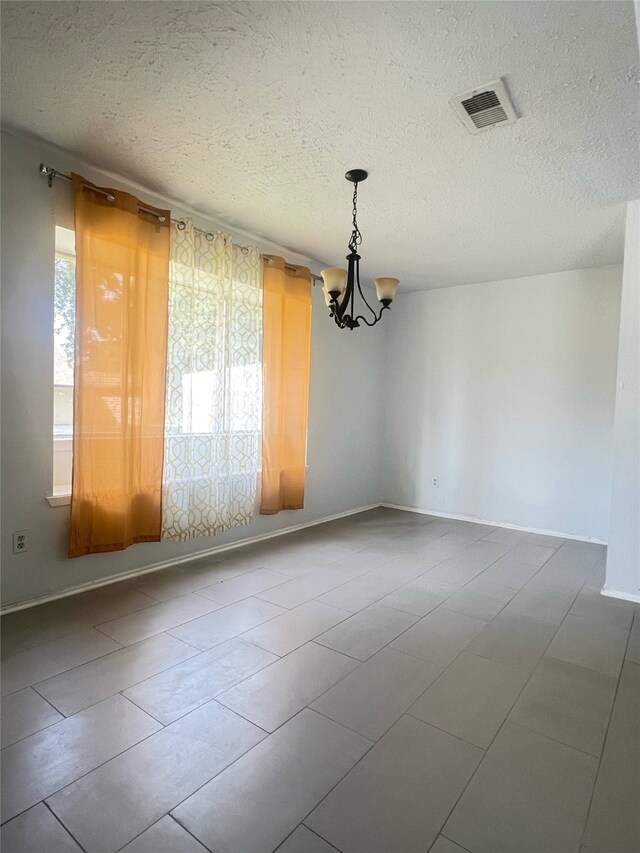 2134 Collingsfield Dr, Sugar Land, TX 77478 - spare room featuring a chandelier, a textured ceiling, baseboards, and tile patterned flooring