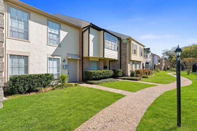 10345 Longmont Dr, Houston, TX 77042 - view of front of property with a residential view, a front lawn, stucco siding, and brick siding