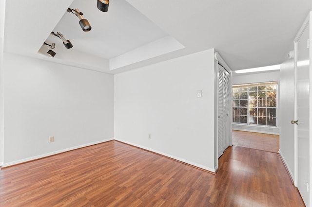 10345 Longmont Dr, Houston, TX 77042 - empty room with wood finished floors, a raised ceiling, and baseboards
