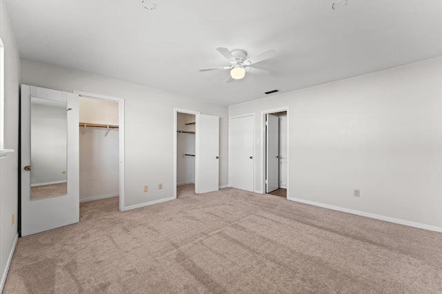 10345 Longmont Dr, Houston, TX 77042 - unfurnished bedroom featuring light colored carpet, baseboards, multiple closets, and ceiling fan