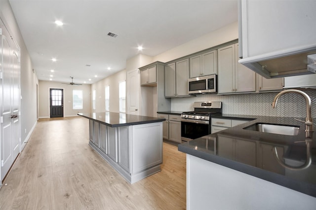 2517 S Houston Ave, Pearland, TX 77581 - kitchen with stainless steel appliances, a sink, dark countertops, gray cabinets, and backsplash