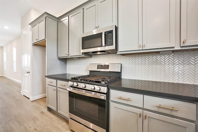 2517 S Houston Ave, Pearland, TX 77581 - kitchen with appliances with stainless steel finishes, dark countertops, gray cabinetry, decorative backsplash, and light wood-style flooring