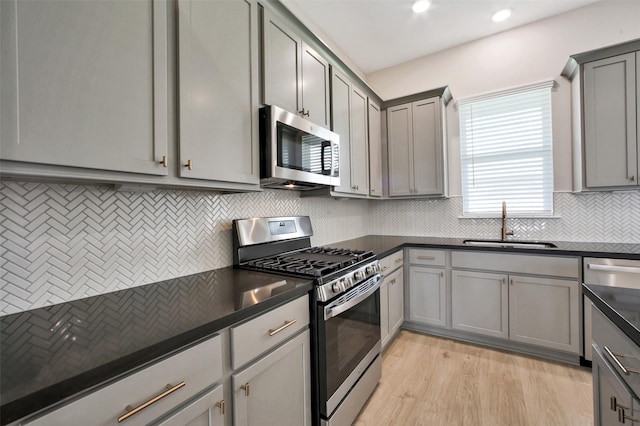 2517 S Houston Ave, Pearland, TX 77581 - kitchen featuring stainless steel appliances, gray cabinetry, dark countertops, a sink, and recessed lighting