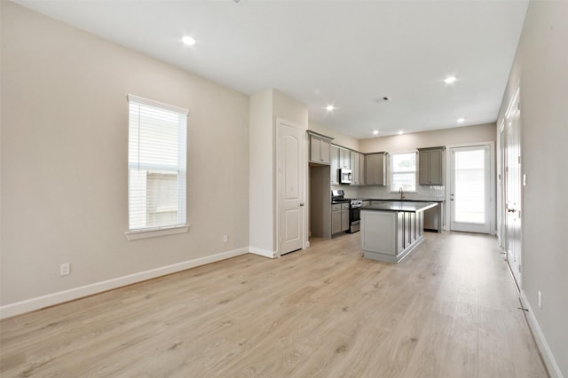 2517 S Houston Ave, Pearland, TX 77581 - kitchen featuring appliances with stainless steel finishes, light wood-style flooring, baseboards, a kitchen island, and recessed lighting