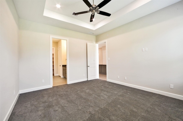 2517 S Houston Ave, Pearland, TX 77581 - unfurnished bedroom with dark colored carpet, baseboards, a raised ceiling, and ensuite bathroom