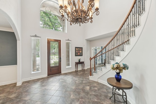 12106 Via Chianti Ct, Cypress, TX 77429 - foyer featuring baseboards, arched walkways, stairway, dark stone finish floors, and a high ceiling