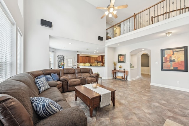 12106 Via Chianti Ct, Cypress, TX 77429 - living room featuring arched walkways, ceiling fan, baseboards, and a towering ceiling