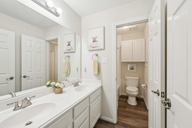 12106 Via Chianti Ct, Cypress, TX 77429 - bathroom with wood finished floors, toilet, double vanity, and baseboards