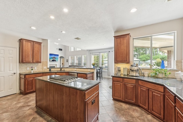 12106 Via Chianti Ct, Cypress, TX 77429 - kitchen featuring stainless steel appliances, a center island, tasteful backsplash, a peninsula, and tile patterned floors