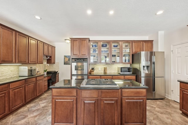 12106 Via Chianti Ct, Cypress, TX 77429 - kitchen featuring stainless steel appliances, tasteful backsplash, a kitchen island, recessed lighting, and glass insert cabinets
