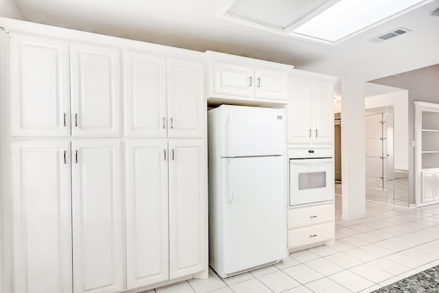 3920 Blackberry Ln, Port Arthur, TX 77642 - kitchen featuring white appliances, white cabinets, and light tile patterned floors