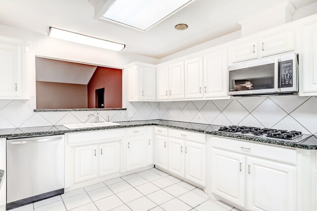 3920 Blackberry Ln, Port Arthur, TX 77642 - kitchen with appliances with stainless steel finishes, a sink, tasteful backsplash, and white cabinets